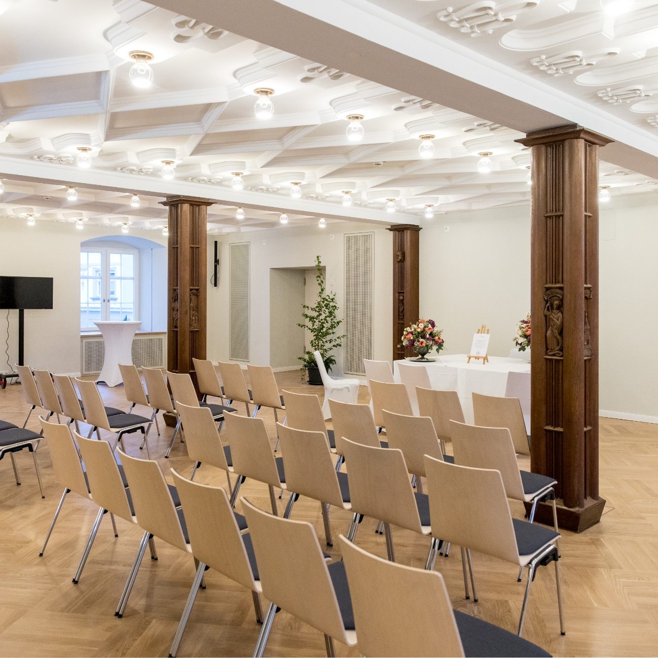 Kleiner Saal Heller Veranstaltungsraum mit Stühlen in Reihen und festlicher Dekoration.