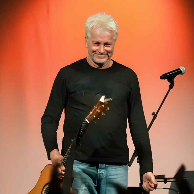 Foto von Werner Schmidbauer mit Gitarre in der Hand